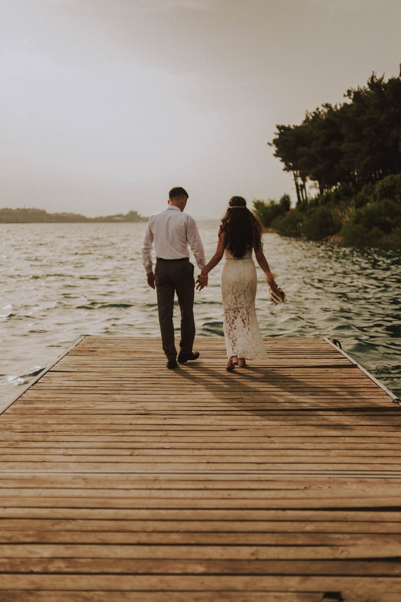 wedding couple walking on pier