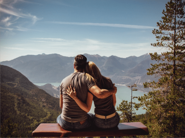 Couple sitting on bench with scenic view
