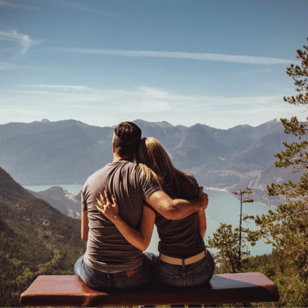 Couple sitting on bench with scenic view